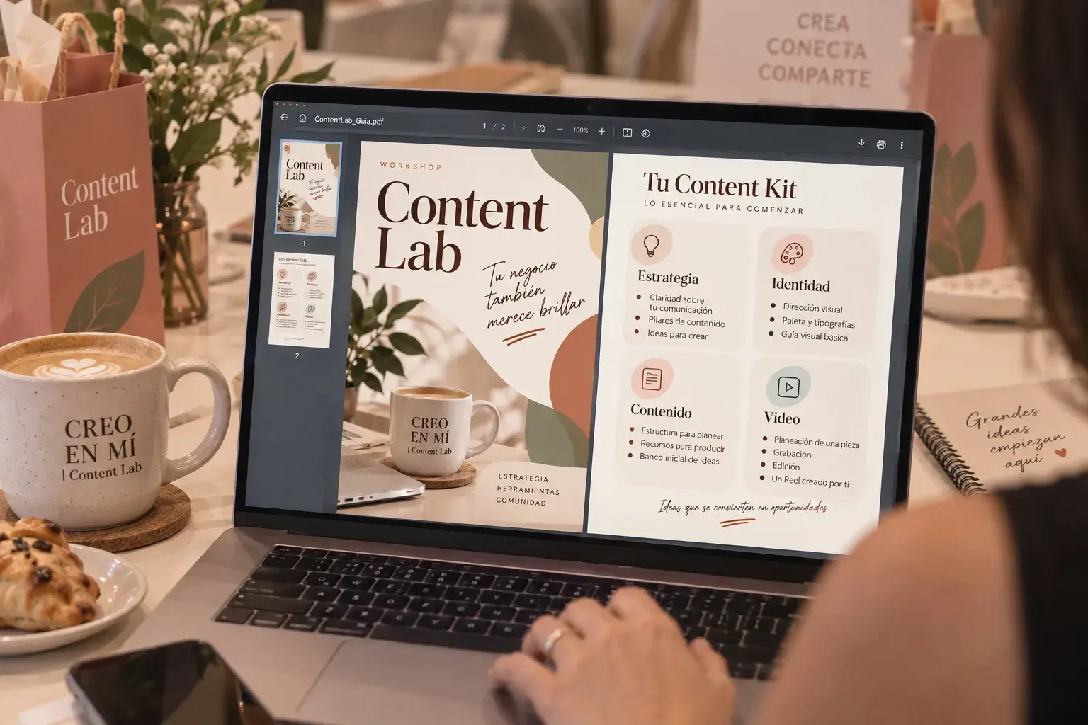 Laptop mostrando el Content Kit del workshop, junto a un café y pan dulce